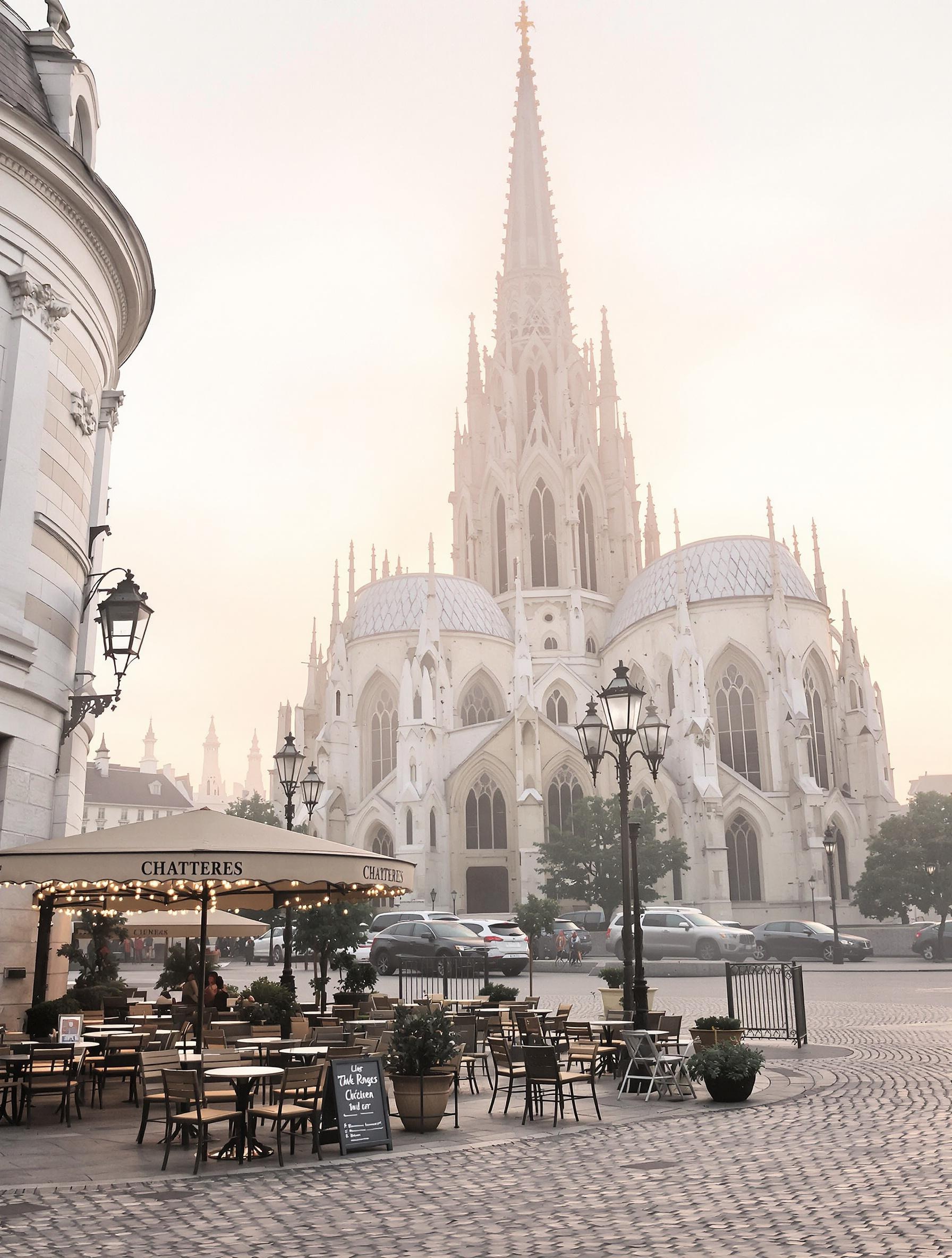 Aube sur la place de la Cathédrale de Chartres, rues pavées désertes, terrasse de café avec vue directe sur la flèche sud.