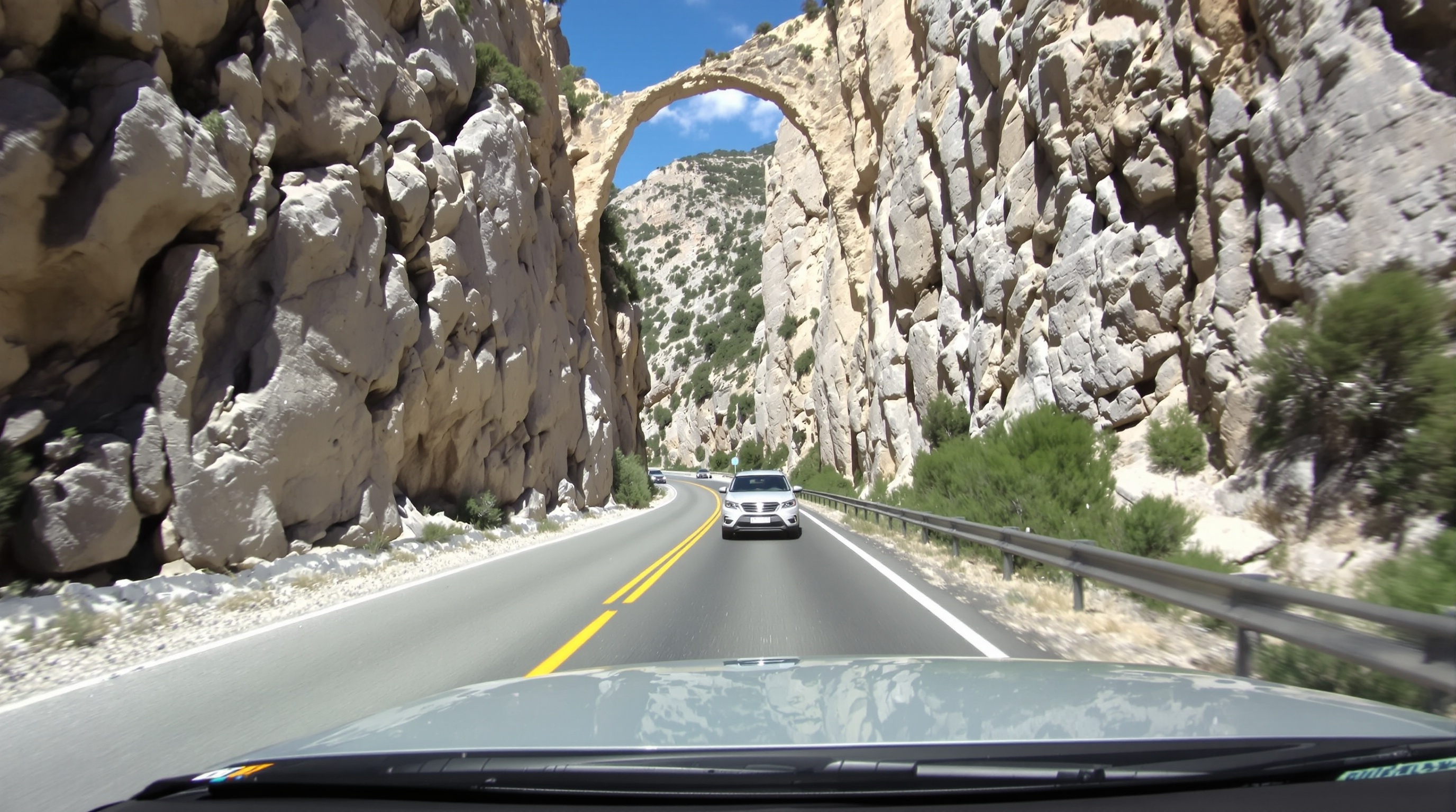 Route très étroite D623 vue depuis l’habitacle d’une voiture avec un véhicule arrivant en face