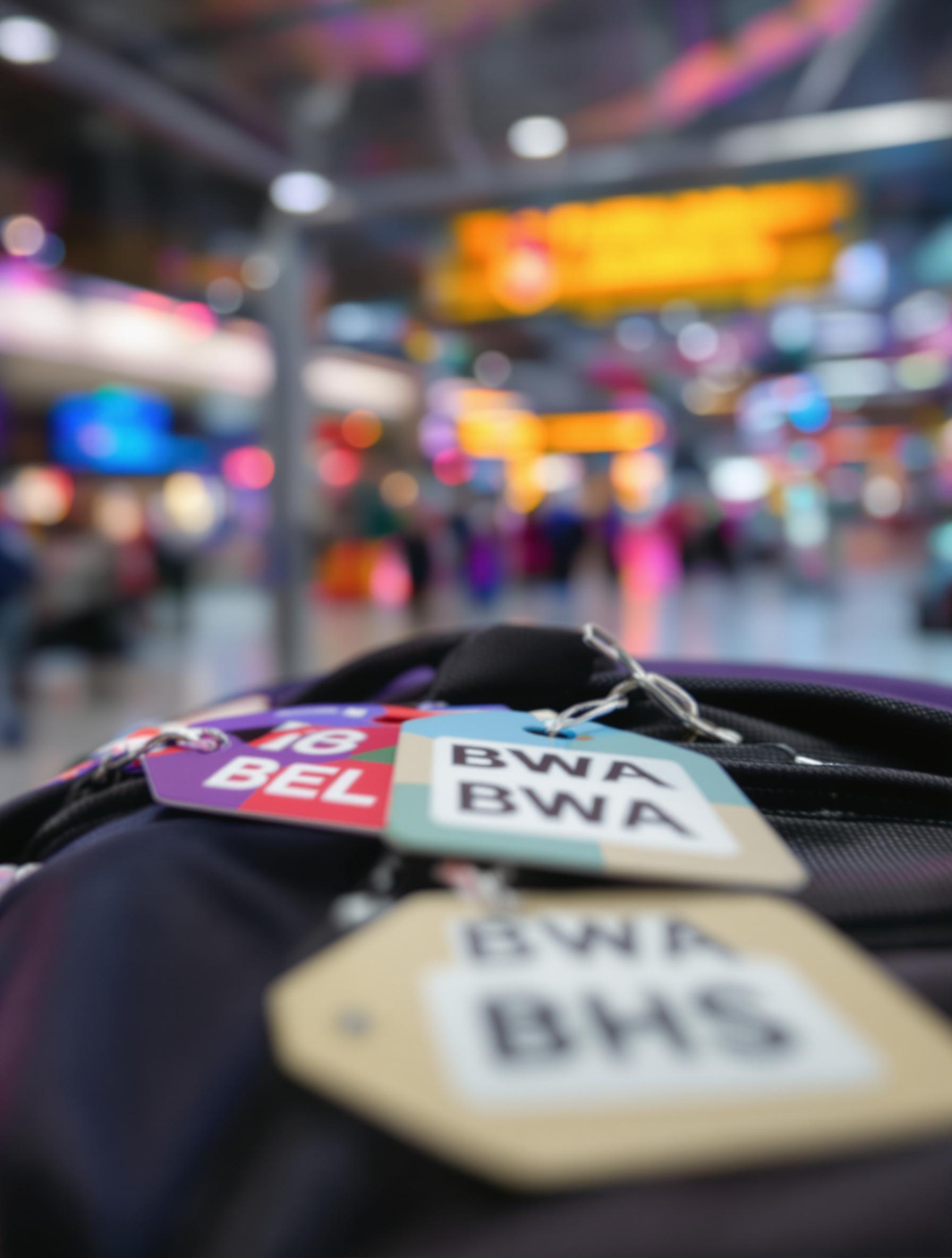 Gros-plan d’étiquettes bagages montrant différents codes ISO des pays en B.