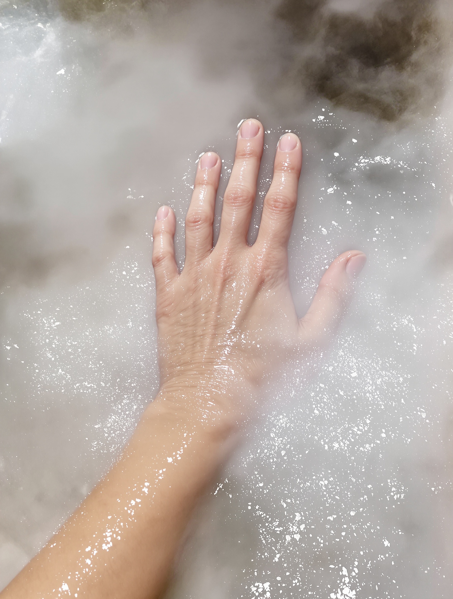 Main luisante sortant des eaux sulfureuses des Cascate del Mulino